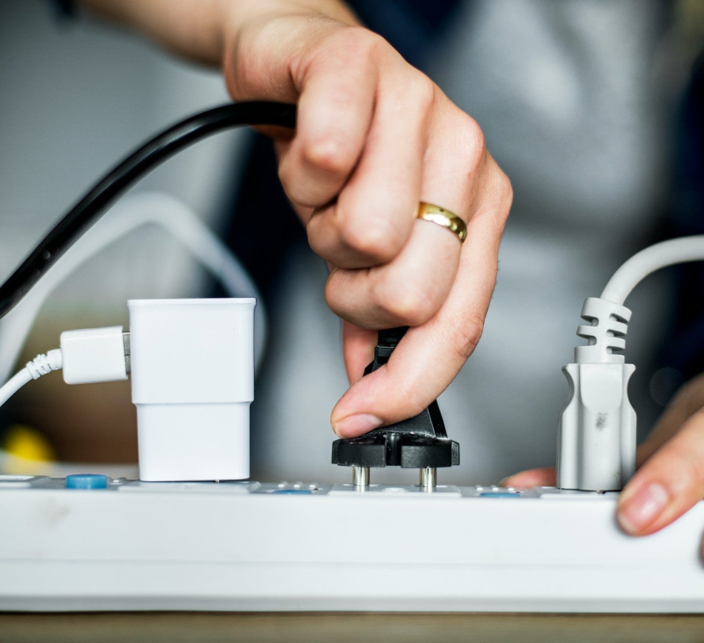 lady plugging in electronics in power strip